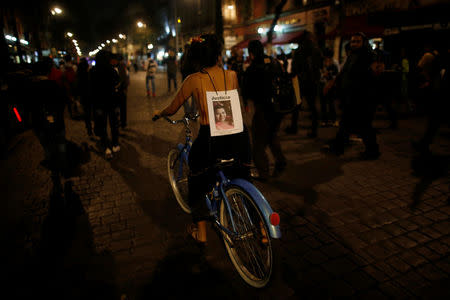 An activist displays a picture of a victim on her back during a march against femicide on the Day of the Dead in Mexico City, Mexico, November 1, 2017. The bold word in the photo reads: "Justice". REUTERS/Carlos Jasso