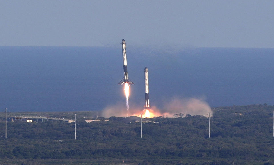 FILE - In this Thursday, April 11, 2019 file photo, SpaceX lands two of the first-stage boosters side by side, eight minutes after liftoff at the Kennedy Space Center in Cape Canaveral, Fla. (AP Photo/John Raoux)