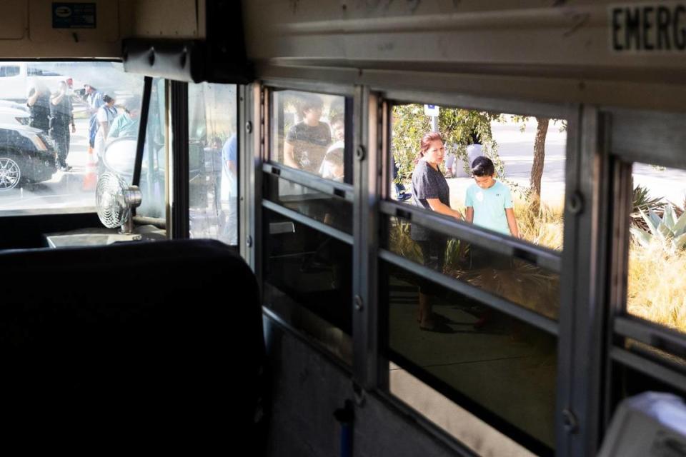 People wait in a line to get children’s haircuts from Jordan Allsup with CleanUP on a bus converted to a barbershop Tuesday, Aug. 9, 2022, in Fort Worth. CleanUP hosts events throughout the area to offer free haircuts and clothing.