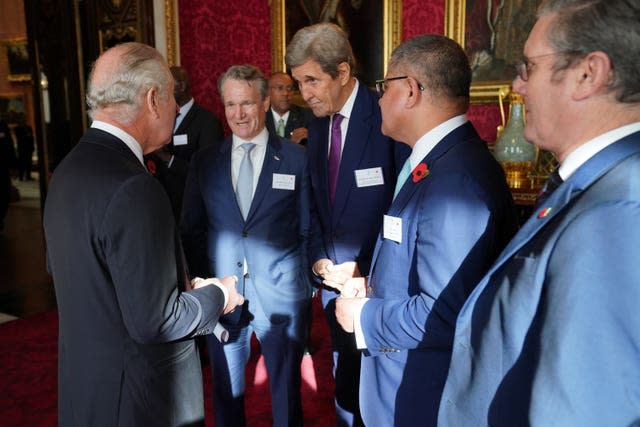 The King speaks with, John Kerry and Cop26 President, Alok Sharma during a reception at Buckingham Palace