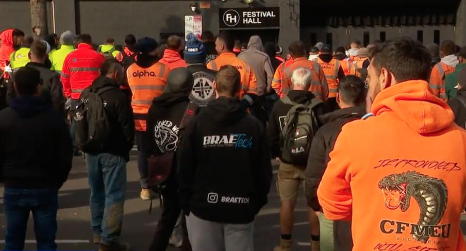 Tradies from behind in hi-vis outside Festival Hall.