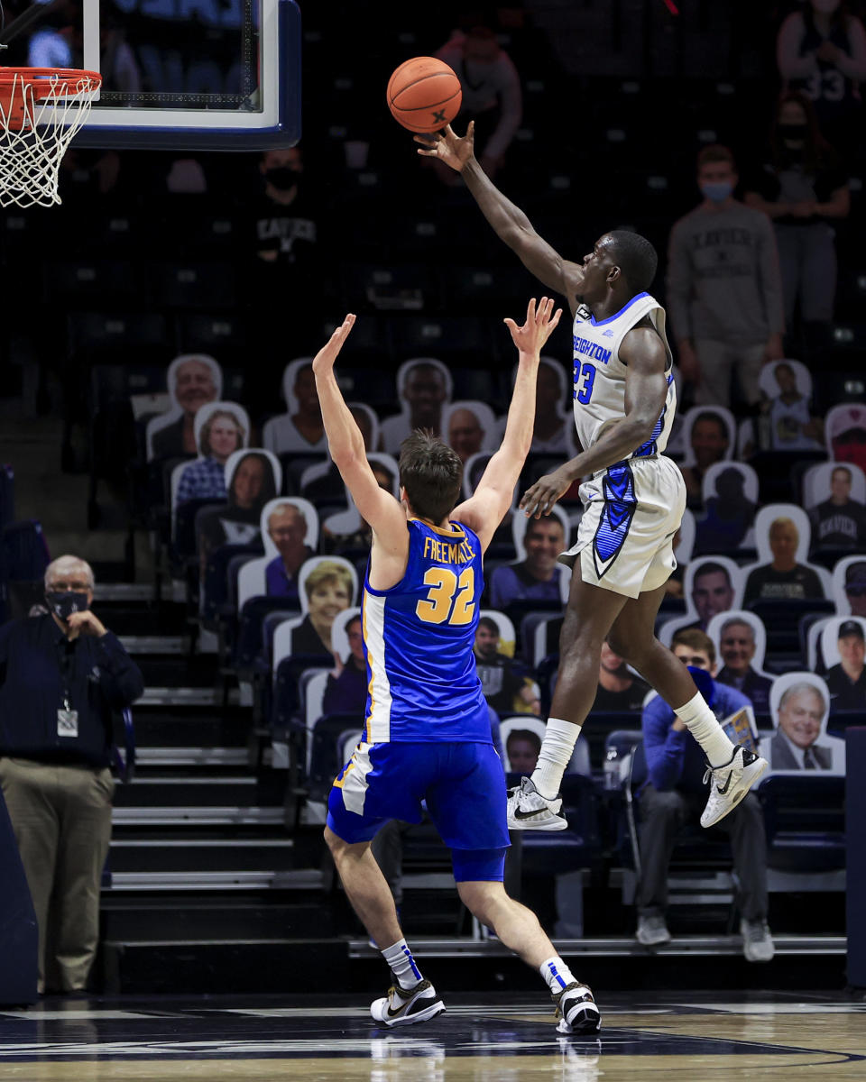 Xavier forward Zach Freemantle (32) defends as Creighton forward Damien Jefferson drives to the basket in the first half of an NCAA college basketball game, Saturday, Feb. 27, 2021, in Cincinnati. (AP Photo/Aaron Doster)