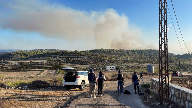 FILE PHOTO: Visual journalists film cross-border shelling at a site near the village of Alma al-Chaab in Lebanon