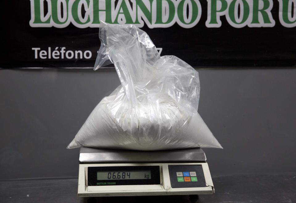 In this Jan. 26, 2014 photo, a bag of cocaine that was found in the baggage of Liz Rabines, from Spain, sits on a scale at the anti-narcotics police station inside the Jorge Chavez International Airport in Lima, Peru. In Peru, drug mule sentences range that minimum to 15 years. But inmates must stay in the country, even if paroled, until their full sentence ends and they’ve paid their fines. (AP Photo/Martin Mejia)