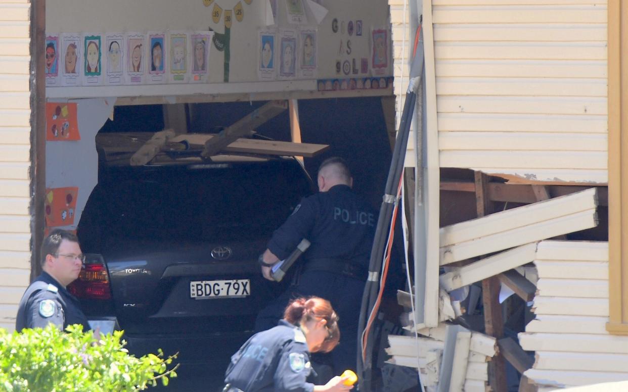 New South Wales emergency services personnel and police inspect a vehicle that crashed into a primary school classroom in the Sydney suburb of Greenacre - REUTERS