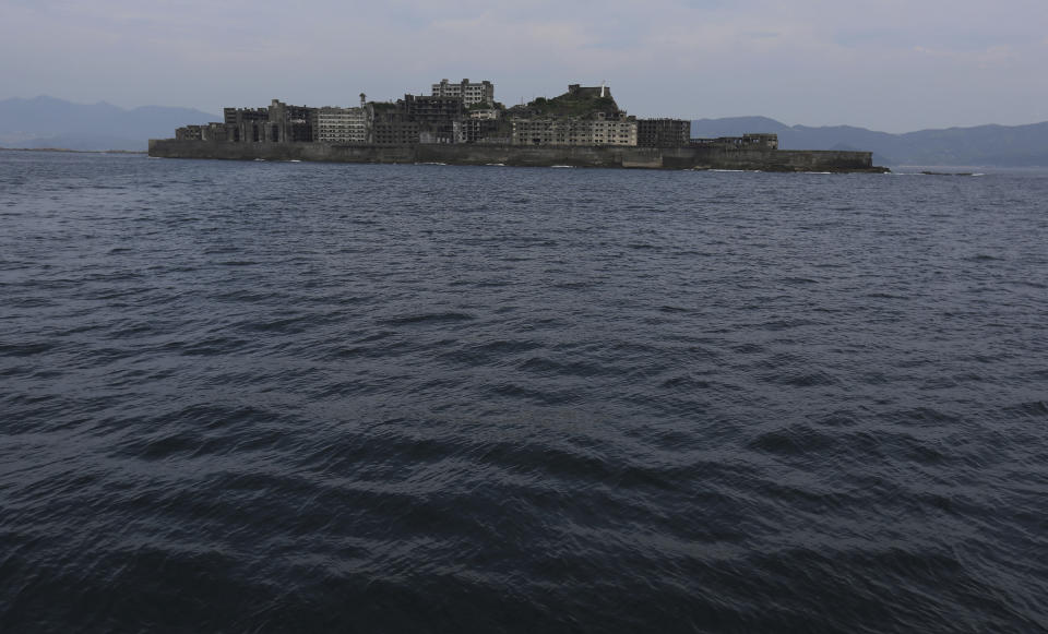 FILE - In this June 29, 2015, file photo, Hashima Island, commonly known as Gunkanjima, which mean "Battleship Island," is seen off Nagasaki, Nagasaki Prefecture, southern Japan. Gunkanjima was among the settings for a dark chapter in Japan’s history, when hundreds of thousands of people were brought from the Korean Peninsula and other Asian nations to work in logging, in mines, on farms and in factories as forced labor. (AP Photo/Eugene Hoshiko, File)