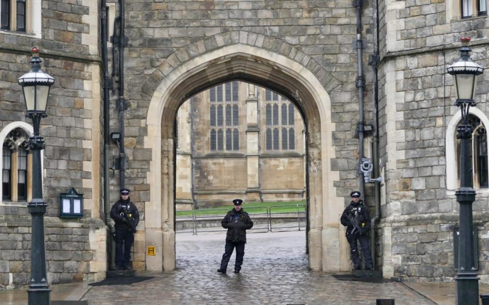 Armed police outside Windsor Castle on a rainy, misty Boxing Day - Shutterstock 