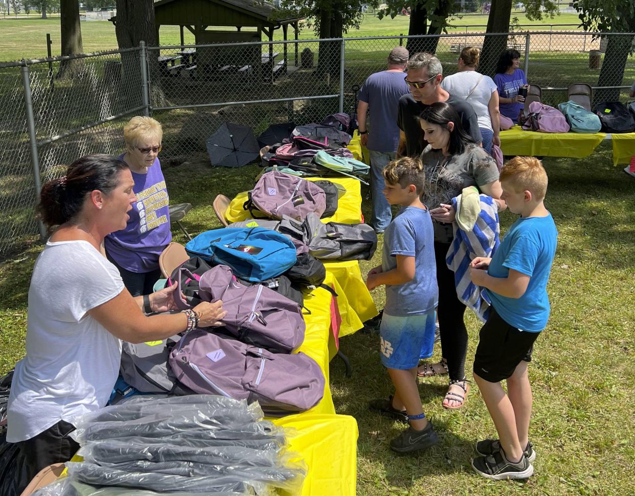 Sebring Local staff, from left, Julie Naples, sixth grade teacher, and Mary Harlan, B.L. Miller Elementary secretary, hand out backpacks filled with supplies on Sunday, Aug. 6, 2023, to Brantley Miller and Zolan Sayre, students who will enter fourth grade in the fall.