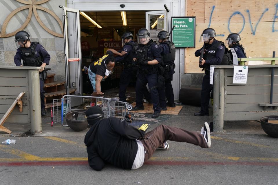 Protesters are thrown out of a Whole Foods Market in L.A.'s Fairfax District on Saturday.