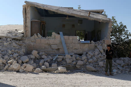 A boy inspects a damaged site after shelling in the rebel held town of Hass, south of Idlib province, Syria October 26, 2016. REUTERS/Ammar Abdullah