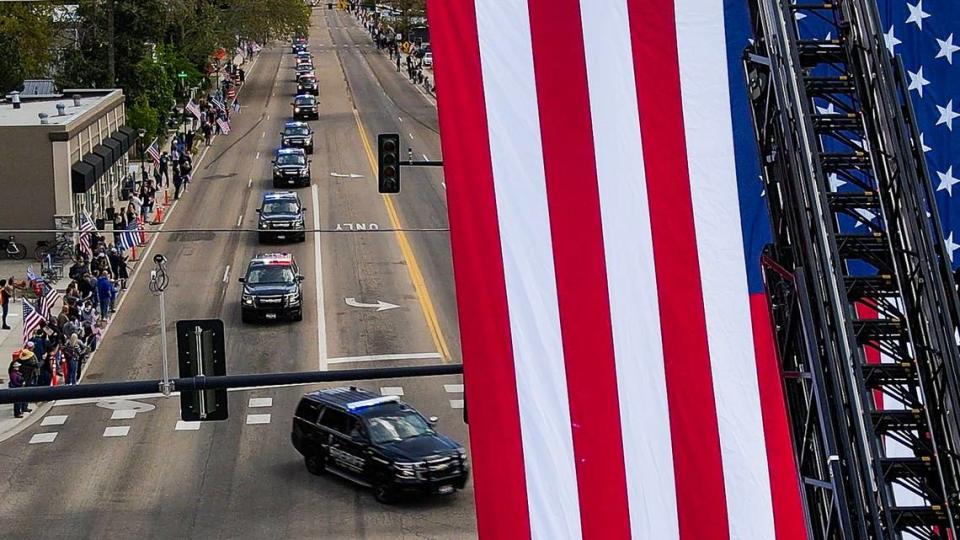 A procession of law enforcement vehicles passes a U.S. flag in remembrance of Ada County Sheriff’s Deputy Tobin Bolter, who was killed in the line of duty.