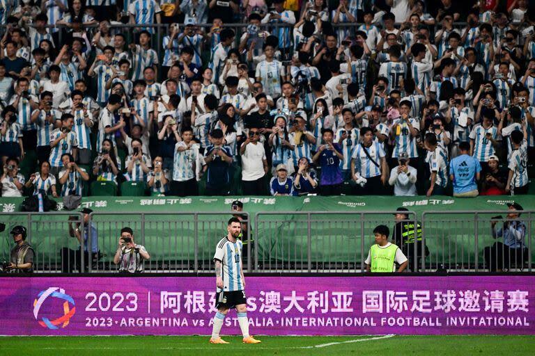 Lionel Messi en el partido ante Australia; de fondo, la multitud de hinchas chinos que alentaron a la selección argentina