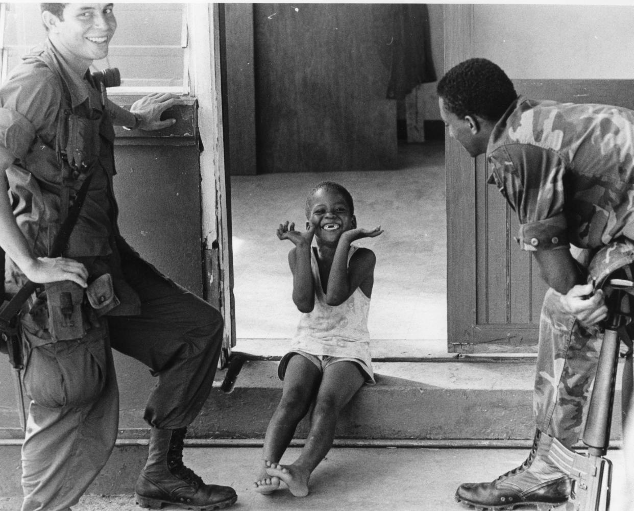 Unidentified paratroopers talk to a child in Grenada in November 1983.