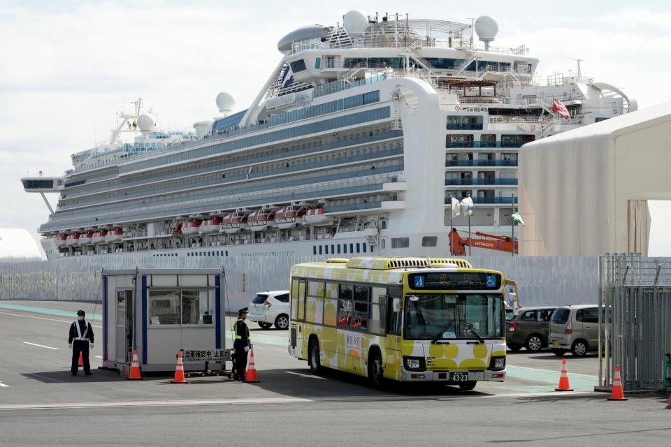 A bus carrying the passengers from the quarantined Diamond Princess cruise ship leaves a port in Yokohama (AP)