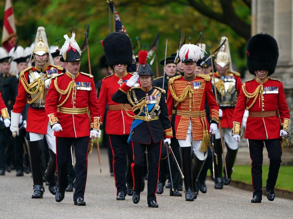 Princess Anne leads members of the armed forces into the Buckingham Palace mall after King Charles III's coronation.