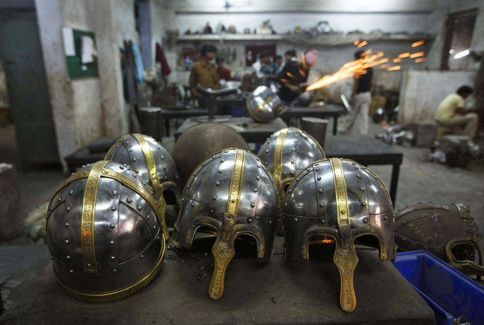 In this, June 2, 2012 photograph, helmets being prepared for a Hollywood period movie are kept together at a workshop owned by Indian businessman Ashok Rai, unseen, in Sahibabad, India. From Hollywood war movies to Japanese Samurai films to battle re-enactments across Europe, Rai is one of the world's go-to men for historic weapons and battle attire. (AP Photo/Saurabh Das)