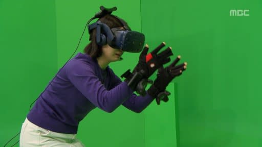 But in the real world, Jang was standing in front of a studio green screen, wearing a virtual reality headset and touch-sensitive gloves