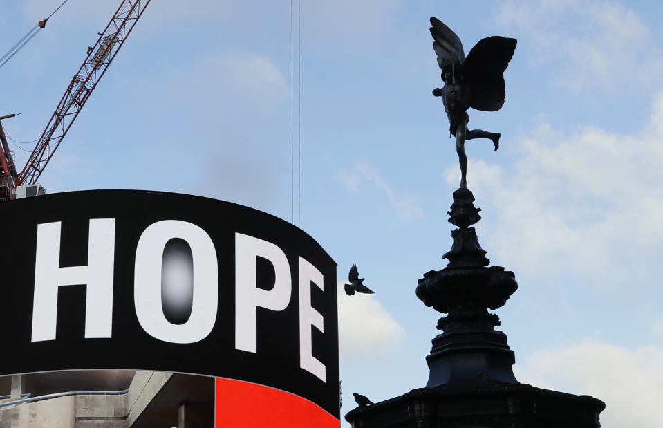 An advert shows the word 'Hope' watched over by a statue of Eros, the winged Greek god of love, at Piccadilly Circus in London, Wednesday, Jan. 6, 2021. Britain's Prime Minister Boris Johnson has ordered a new national lockdown for England which means people will only be able to leave their homes for limited reasons, with measures expected to stay in place until mid-February. (AP Photo/Kirsty Wigglesworth)