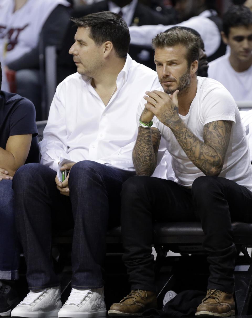 Former soccer player David Beckham, right, of England, sits with Bolivian businessman Marcelo Claure, during Game 1 of an NBA basketball Eastern Conference semifinal playoff series between the Miami Heat and Brooklyn Nets, Tuesday, May 6, 2014, in Miami. (AP Photo/Lynne Sladky)