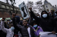 People shout slogans in the Belgium capital, Brussels, Wednesday, Jan. 13, 2021, during a protest asking for authorities to shed light on the circumstances surrounding the death of a 23-year-old Black man who was detained by police last week in Brussels. The demonstration in downtown Brussels was largely peaceful but was marred by incidents sparked by rioters who threw projectiles at police forces and set fires before it was dispersed. (AP Photo/Francisco Seco)