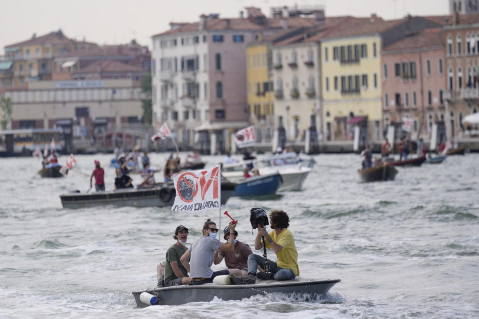 "No Big Ships" activists stage a protest as the MSC Orchestra cruise ship leaves Venice, Italy, Saturday, June 5, 2021. The 92,409-ton, 16-deck MSC Orchestra cruise ship, the first cruise ship leaving Venice since the pandemic is set to depart Saturday amid protests by activists demanding that the enormous ships be permanently rerouted out the fragile lagoon, especially Giudecca Canal through the city's historic center, due to environmental and safety risks. The ship passed two groups of protesters: pro-cruise advocates whose jobs depend on the industry as well as protesters who have been campaigning for years to get cruise ships out of the lagoon. The cruiser passed two groups of protesters: pro-cruise advocates whose jobs depend on the industry as well as protesters who have been campaigning for years to get cruise ships out of the lagoon. (AP Photo/Antonio Calanni)