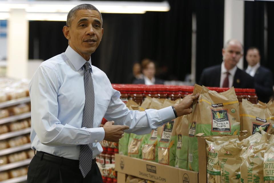 President Barack Obama holds up a bag of tortilla chips during a visit at a Costco store in Lanham, Md., Wednesday, Jan. 29, 2014, where he spoke about raising the minimum wage the morning after his State of the Union address. (AP Photo/Charles Dharapak)