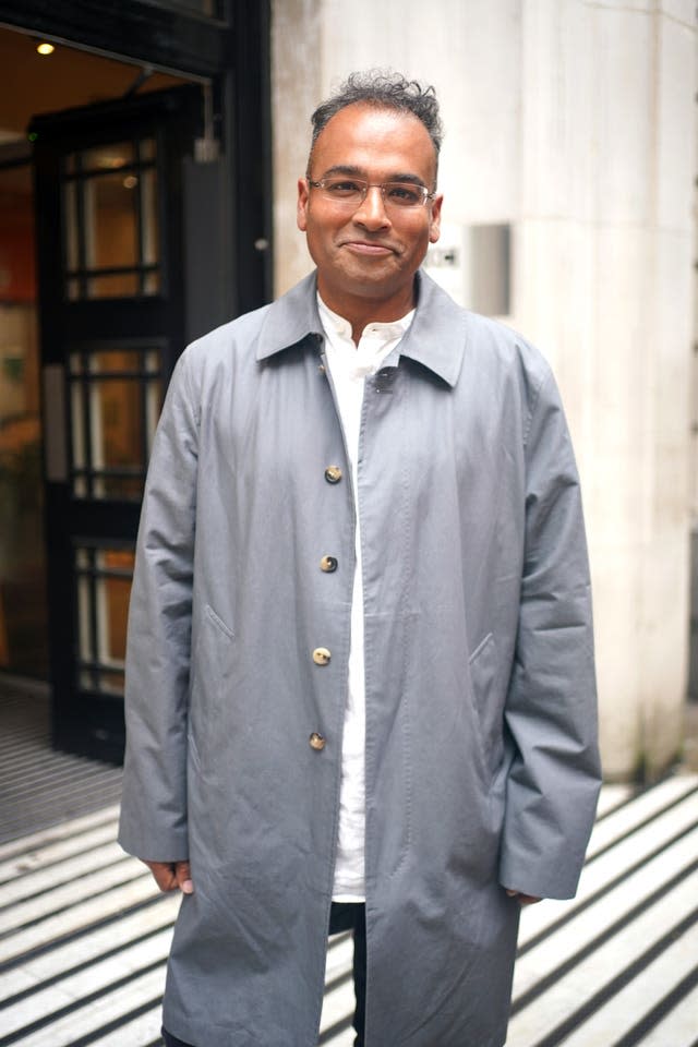 Krishnan Guru-Murthy in a grey coat and a white top