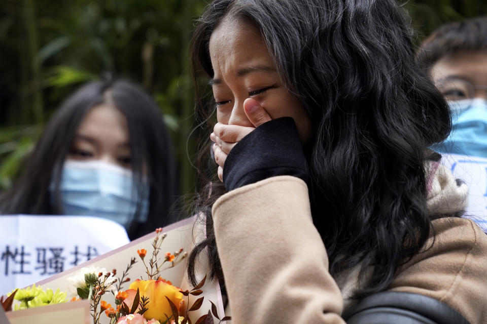 Zhou Xiaoxuan weeps as she speaks to her supporters upon arrival at a courthouse in Beijing, Wednesday, Dec. 2, 2020. Zhou, a Chinese woman who filed a sexual harassment lawsuit against a TV host, told dozens of cheering supporters at a courthouse Wednesday she hopes her case will encourage other victims of gender violence in a system that gives them few options to pursue complaints. (AP Photo/Andy Wong)