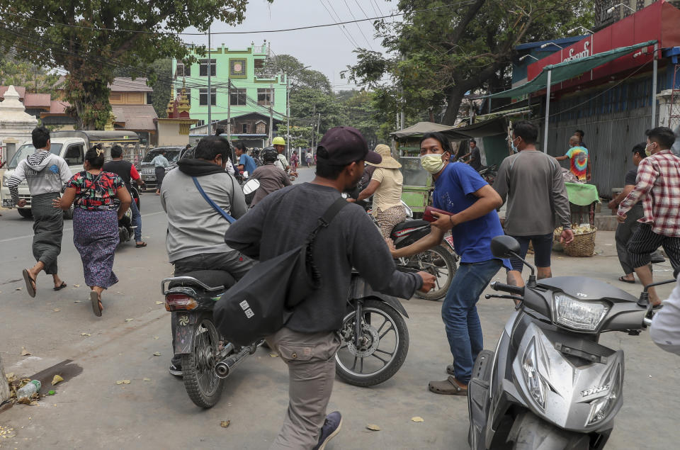 People flee as a convoy of soldiers and policemen arrive to remove makeshift barricades made by anti-coup protesters in Mandalay, Myanmar, Thursday, March 11, 2021. (AP Photo)