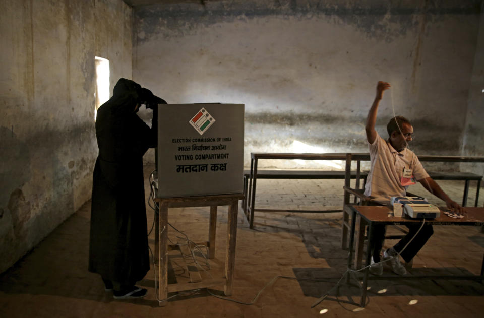 FILE - In this Thursday, April 11, 2019 file photo, an Indian Muslim woman casts her vote at a polling station in village Sawaal near Meerut, Uttar Pradesh, India. The final phase of India’s marathon general election will be held on Sunday, May 19. The first of the election’s seven staggered phases was held on April 11. Vote counting is scheduled to start on May 23. India has 900 million eligible voters. (AP Photo/Altaf Qadri)