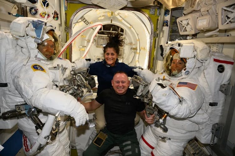 Sunita Williams and Butch Wilmore (center) pose with astronauts Michael Barratt (left) and Tracy Dyson (right).