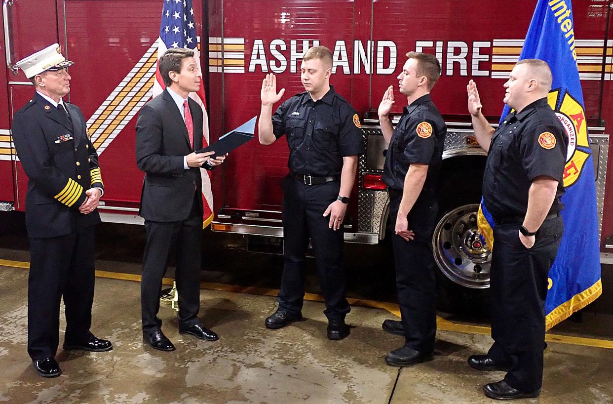 Ashland Fire Chief Rick Anderson watches as Mayor Matt Miller swears in three new firefighters/paramedics, left to right, Zachery Lohr, Jody Erickson, and Chris Gore.