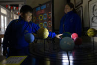 A blind child interacts with a representation of the solar system during sensorial experience with tools created by NASA and Edinburgh University to experience an eclipse, at the Helen Keller school in Santiago, Chile, Tuesday, June 25, 2019. The event comes exactly one week ahead of a total solar eclipse which is set to be fully visible in various South American countries, including Chile. (AP Photo/Esteban Felix)