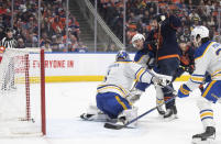 Buffalo Sabres goalie Ukko-Pekka Luukkonen (1) is scored against as Sabres' Henri Jokiharju (10) and Edmonton Oilers' Zach Hyman (18) battle in front of the net during second-period NHL hockey game action in Edmonton, Alberta, Thursday March 21, 2024. (Jason Franson/The Canadian Press via AP)