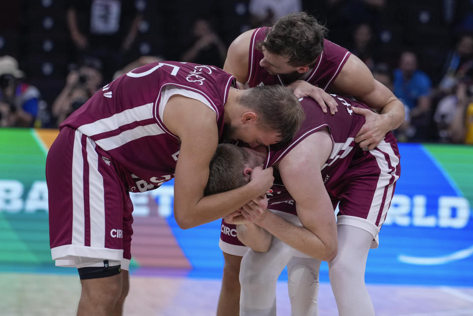 Latvian players react following their two point loss to Germany in their Basketball World Cup quarterfinal in Manila, Philippines, Wednesday, Sept. 6, 2023. (AP Photo/Michael Conroy)