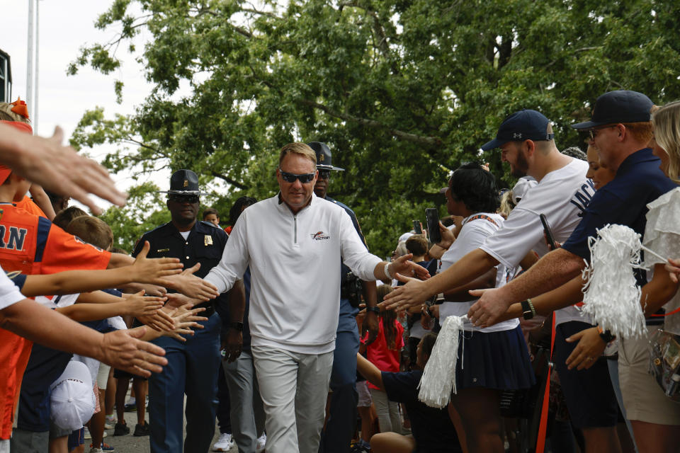 Auburn head coach Hugh Freeze greets fans as he walks to the stadium in his first Tiger Walk before an NCAA college football game against Massachusetts Saturday, Sept. 2, 2023, in Auburn, Ala. (AP Photo/Butch Dill)