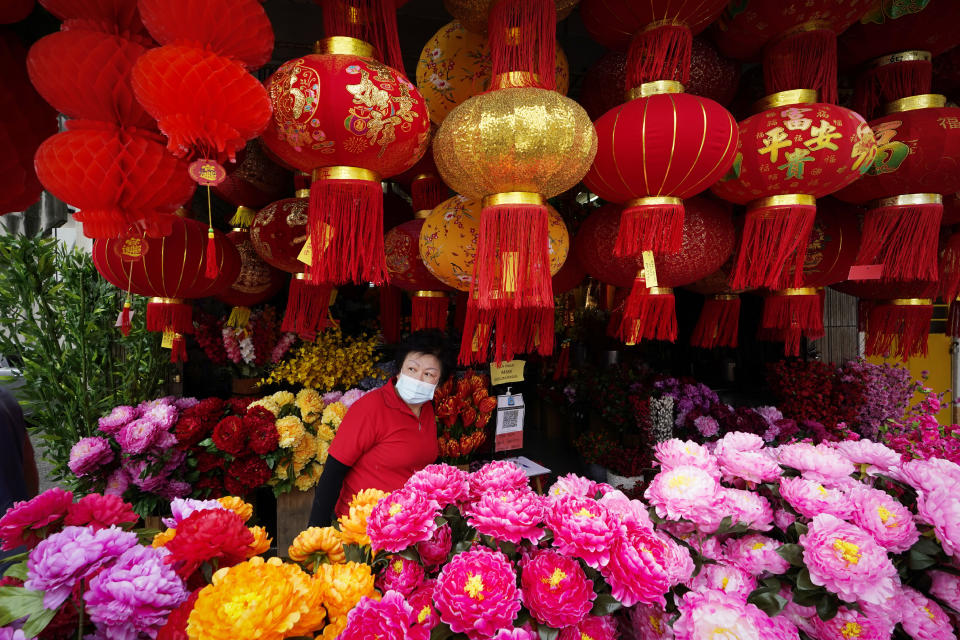 A woman wearing a face mask looks through Chinese New Year lantern decorations at a shop in Kuala Lumpur, Malaysia, Tuesday, Jan. 12, 2021. Malaysia's king Tuesday approved a coronavirus emergency that will prorogue parliament and halt any bids to seek a general election in a political reprieve for embattled Prime Minister Muhyiddin Yassin. (AP Photo/Vincent Thian)