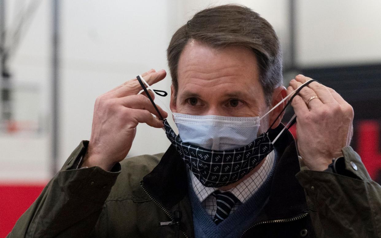 Congressman Jim Himes, D-Conn., adjusts his two masks during a tour of a vaccination clinic - Mark Lennihan /AP