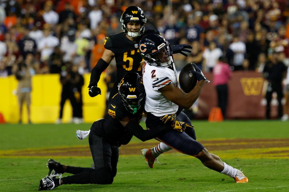 Chicago Bears wide receiver DJ Moore catches a pass as Washington Commanders cornerback Emmanuel Forbes makes the tackle during the third quarter at FedExField.