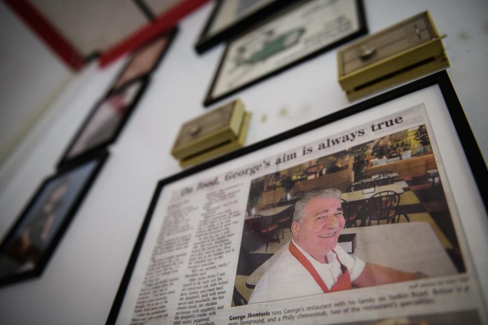 A newspaper clipping with a picture of George Skenteris hangs on the wall along with other family photos and memorabilia at George's on Yadkin Road. The restaurant closed permanently on Saturday.