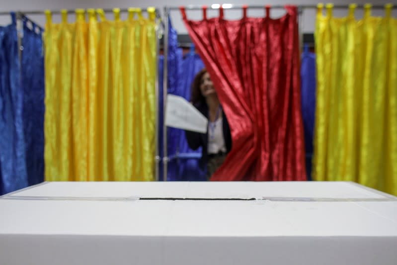 A woman exits a polling booth after voting in the first round of a presidential election