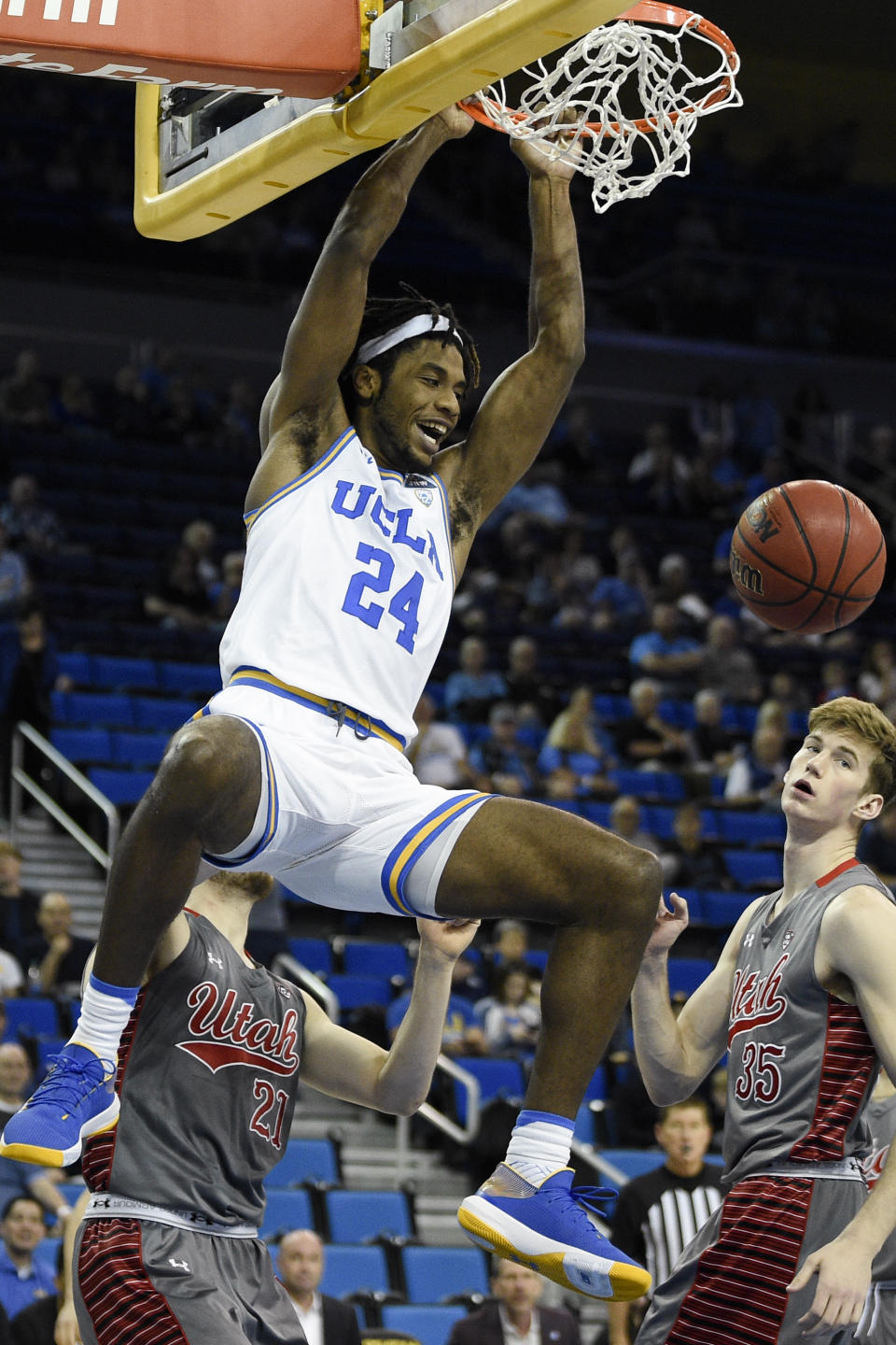 UCLA forward Jalen Hill, left, dunks ball while Utah center Branden Carlson looks on during the first half of an NCAA college basketball game in Los Angeles, Sunday, Feb. 2, 2020. (AP Photo/Kelvin Kuo)