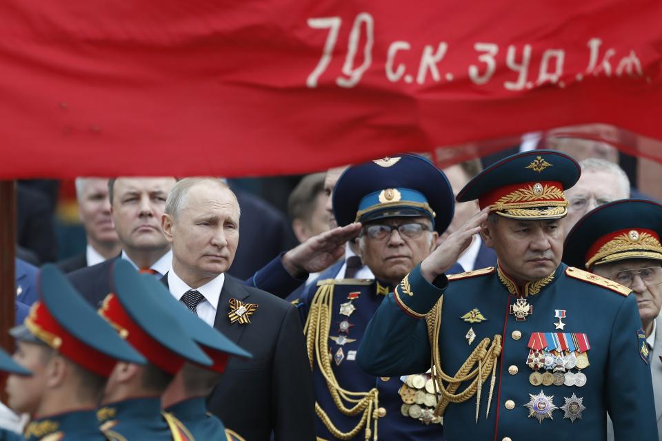 FILE - In this file photo taken on Thursday, May 9, 2019, Russian President Vladimir Putin, left, and Russian Defense Minister Sergei Shoigu, right, attend a wreath-laying ceremony at the Tomb of the Unknown Soldier after the military parade marking 74 years since the victory in WWII in Moscow, Russia. A massive military parade that was postponed by the coronavirus will roll through Red Square this week to celebrate the 75th anniversary of the end of World War II in Europe, even though Russia is continuing to register a steady rise in infections. (AP Photo/Pavel Golovkin, File)