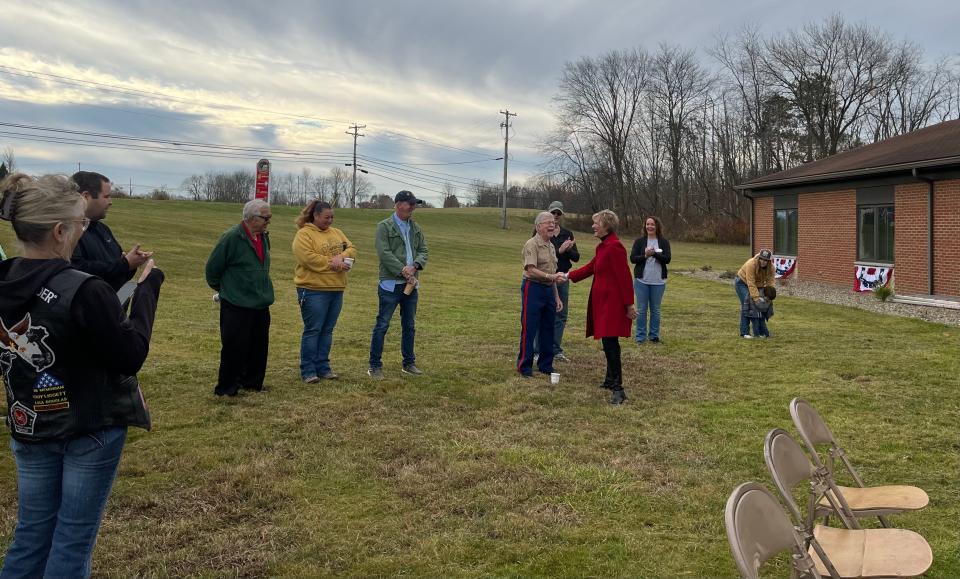 Sandy Upperman, community president for Huntington Bank, presents a challenge coin to Marine veteran Henry Aegerter, at a Veterans Day ceremony at the new Serving Area Military (SAM) Center location in Canal Fulton.