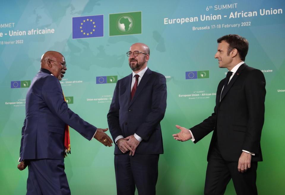 Uganda Foreign minister Odongo Jeje Abubakhar, left, is welcomed by European Council President Charles Michel and French President Emmanuel Macron during arrivals for an EU Africa summit at the European Council building in Brussels, Thursday, Feb. 17, 2022. European Union leaders meet with their African counterparts during a two-day summit in Brussels. The EU wants to re-engage with African nations and counter the growing influence from China and Russia across the continent. (Olivier Hoslet, Pool Photo via AP)