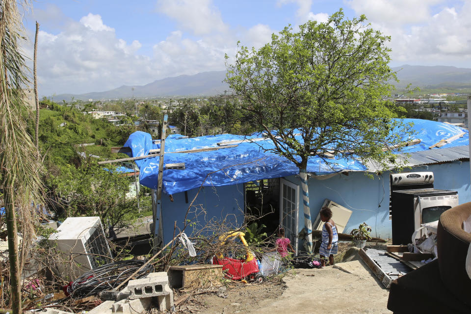 Children play in front of a partially destroyed home in Villa Hugo 2. Can&oacute;vanas, Puerto Rico. October 14, 2017.