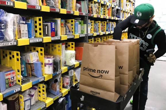 An employee collects items ordered by Amazon.com customers through the company's two-hour delivery service Prime Now in a warehouse in San Francisco, December 20, 2017.