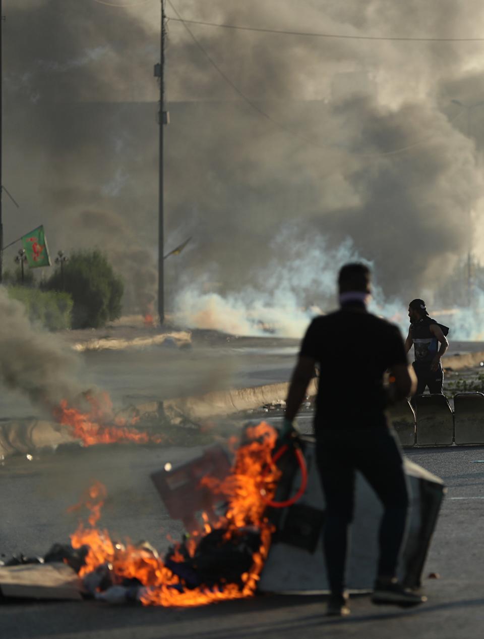 Anti-government protesters set fires and close a street during a demonstration in Baghdad, Iraq, Saturday, Oct. 5, 2019. Iraqi protesters pressed on with angry anti-government rallies across several provinces, in some cases torching party offices, for the fifth day, ignoring appeals for calm from political and religious leaders. Security agencies kept up their heavy crackdown, firing live ammunition and killing more than 14 protesters Saturday. (AP Photo/Hadi Mizban)