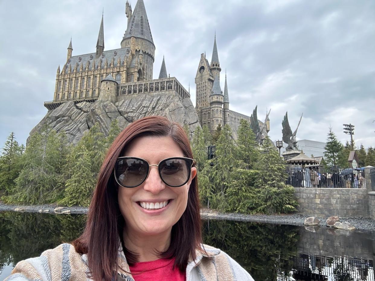 amanda posing in front of hogwarts at universal theme park