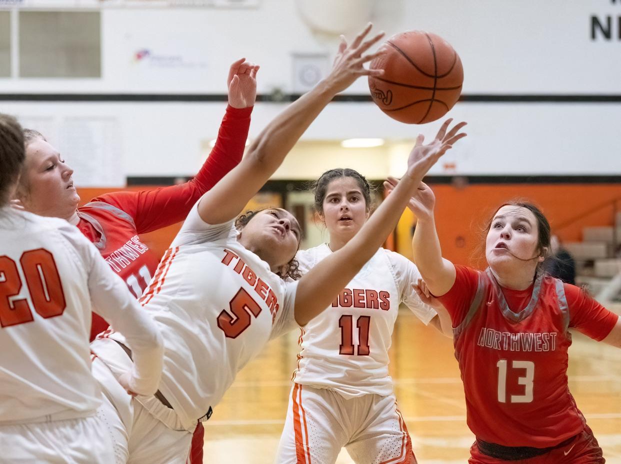 Massillon’s Na Omie Moore (5) reaches for a rebound in front of teammates Riley Hendricks (20) and Hanna Nicola (11) and Northwest’s Ally Sharrer (11) and Lily Lyons (13) during Monday's game.